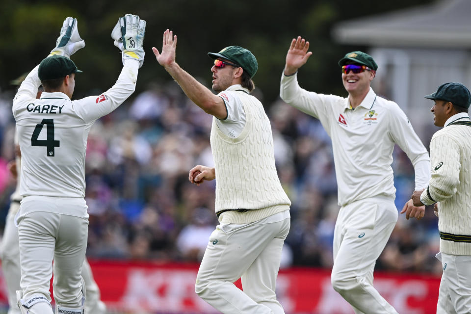 Mitch Marsh, centre, of Australia celebrates with teammates after taking a catch to dismiss New Zealand's Will Young on day one for the second cricket test between New Zealand and Australia in Christchurch, New Zealand, Friday March 8, 2024. (John Davidson/Photosport via AP)