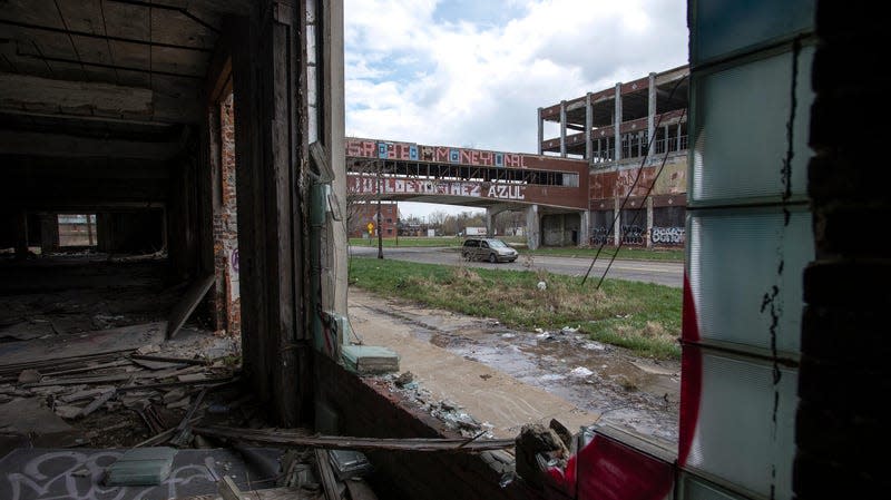 Image of an abandoned auto factory taken from inside showing empty rooms and broken windows. 