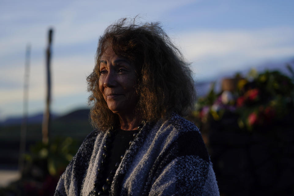 Illona Ilae, a Native Hawaiian from Kailua-Kona, Hawaii, looks on after leaving an offering in front an alter below the Mauna Loa volcano as it erupts Thursday, Dec. 1, 2022, near Hilo, Hawaii. Glowing lava from the world's largest volcano is a sight to behold, but for many Native Hawaiians, Mauna Loa's eruption is a time to pray, make offerings and honor both the natural and spiritual worlds. (AP Photo/Gregory Bull)