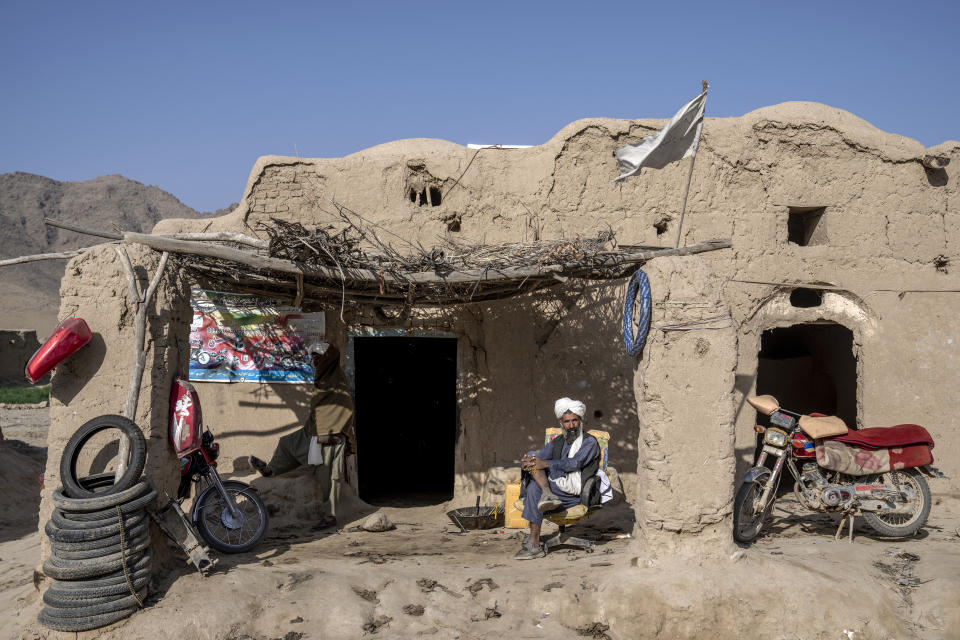 A mechanic waits for customers in front of his shop in a village in a remote region of Afghanistan, on Saturday, Feb. 25, 2023. (AP Photo/Ebrahim Noroozi)