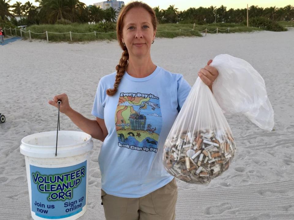 Dara Schoenwald sosteniendo una bolsa de basura en una limpieza oceánica en South Beach en 2015.