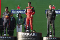 Ferrari driver Charles Leclerc, centre, of Monaco stands on the podium after winning the Australian Formula One Grand Prix in Melbourne, Australia, Sunday, April 10, 2022. Red Bull driver Sergio Perez, left, of Mexico was second and Mercedes driver George Russell of Britain finished third. (AP Photo/Asanka Brendon Ratnayake)