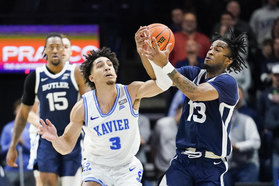 Xavier guard Colby Jones (3) and Butler guard Jayden Taylor (13) fight for the ball during the first half of an NCAA college basketball game, Saturday, March 4, 2023, in Cincinnati. (AP Photo/Joshua A. Bickel)