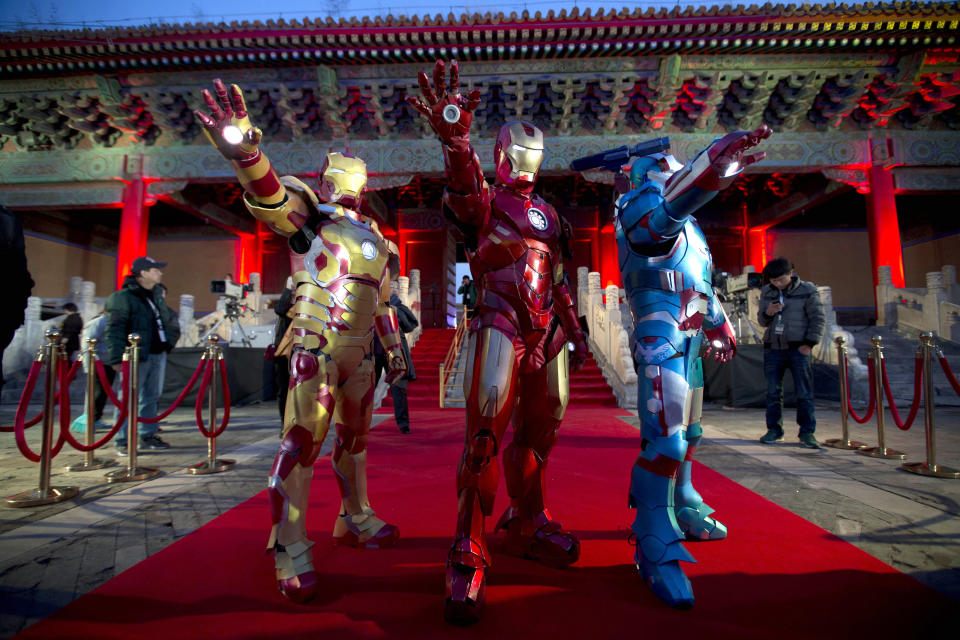 FILE - In this Saturday, April 6, 2013 file photo, Chinese performers dressed as Iron Man pose for photos during a promotional event for the movie "Iron Man 3" before its release in China in early May at the Imperial Ancestral Temple in Beijing's Forbidden City. Hong Kong Disneyland is adding an Iron Man-themed area in the hopes that the Marvel superhero's success at the Chinese box office will help draw more visitors to the underachieving resort. The park said Tuesday, Oct. 8 that the Iron Man Experience is planned to open by late 2016. (AP Photo/Andy Wong, File)