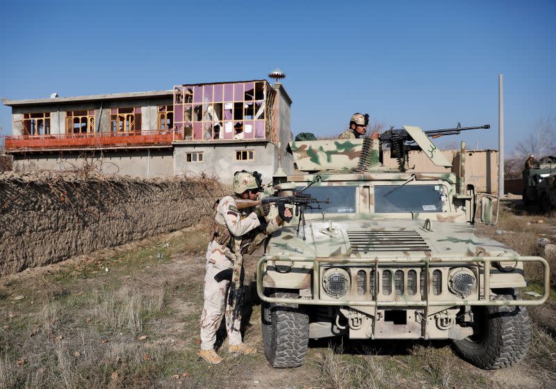 Afghan security forces take position at the site of an attack in a U.S. military air base in Bagram