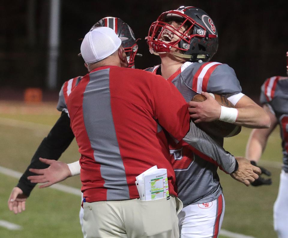 Canton South quarterback Poochie Snyder celebrates the Wildcats win over Northwest with coach Matt Dennison at Canton South on Oct. 21, 2022.