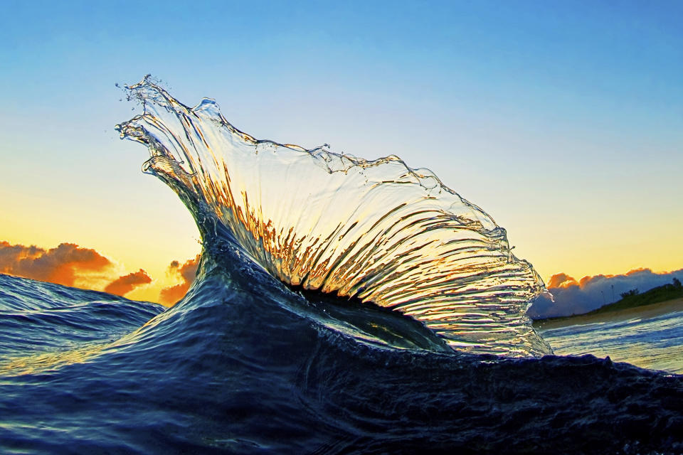 In this undated photo entitled "Marlin," two waves collide at sunrise creating a splash of water that looks like the fin of a marlin on the North Shore of Oahu near Haleiwa, Hawaii. The image appears in photographer Clark Little's new book, "The Art of Waves." (Clark Little via AP)