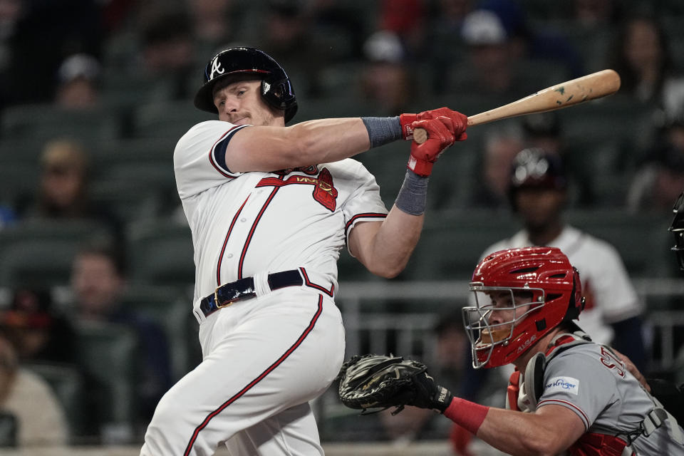 Atlanta Braves' Sean Murphy, left, drives in a run with a double as Cincinnati Reds catcher Tyler Stephenson ooks on in the sixth inning of a baseball game Monday, April 10, 2023, in Atlanta. (AP Photo/John Bazemore)