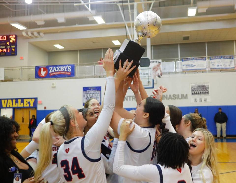 Sacred Heart holds up its trophy after defeating Butler in the 2024 Republic Bank Girls LIT Championship game at Valley High School in Louisville on Jan. 27.