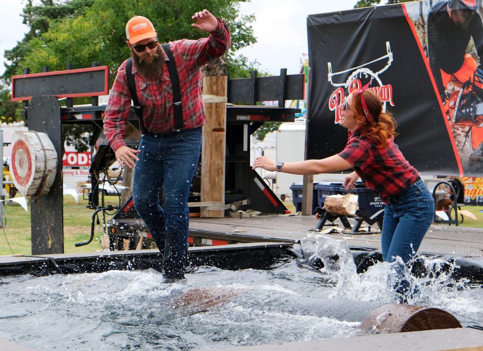 Joe Woodman successfully knocks Gretchen Rothermel of the log at the Paul Bunyan Lumberjack Show during the first day of the Oklahoma State Fair Thursday, Sept. 14, 2023.