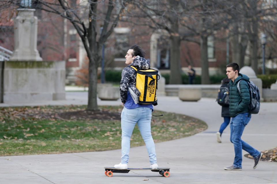 A rider skates near the Engineering Fountain on an electric skateboard Tuesday at Purdue University in West Lafayette, Ind.