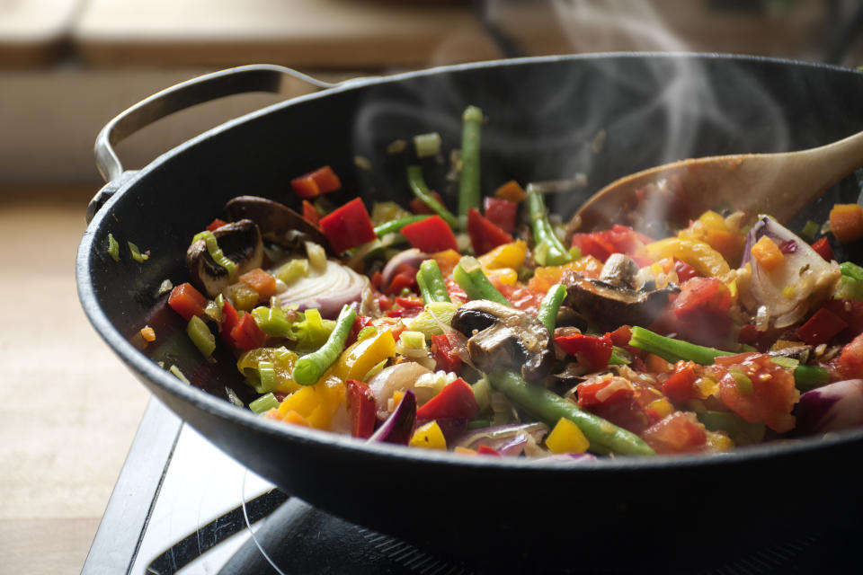 Toss your takeout into a wok and stir fry it up with fresh vegetables from your fridge or freezer. (Photo: fermate via Getty Images)