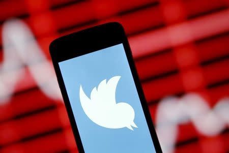 The Twitter logo is shown on smartphone in front of a displayed stock graph in central Bosnian town of Zenica, Bosnia and Herzegovina, in this April 29, 2015 photo illustration. REUTERS/Dado Ruvic