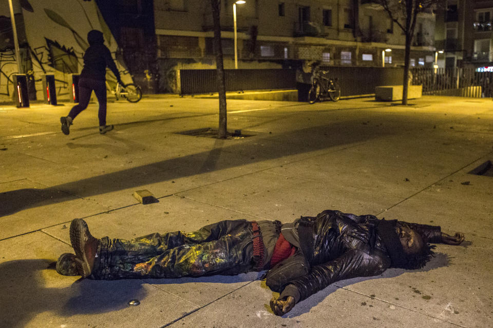 Un hombre herido en los disturbios en el suelo de una calle de Lavapiés (AP).