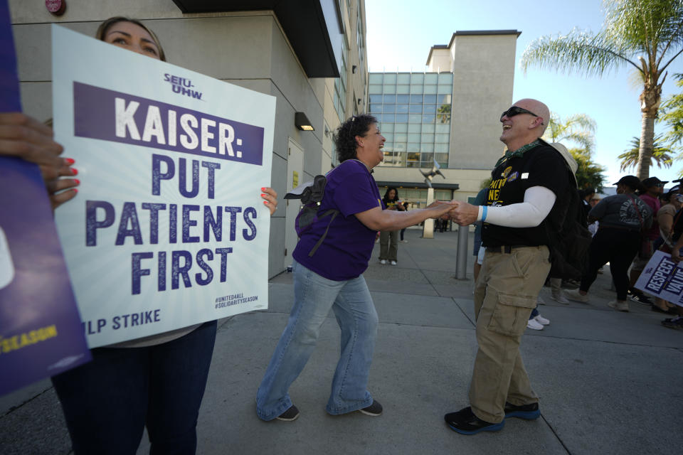 CAPTION CORRECTION CORRECTS NUMBER OF REPRESENTED HEALTH WORKERS: FILE - Kaiser Permanente healthcare workers Selene Lockerbie, left, and her husband Colin Lockerbie dance to celebrate the end of a three day strike outside Kaiser Permanente Los Angeles Medical Center in Los Angeles on Oct. 6, 2023. Unions representing 85,000 health care workers have reached a tentative agreement with industry giant Kaiser Permanente following a strike over wages and staffing levels, the parties announced Friday, Oct. 13, 2023. Details of the agreement were not immediately released, but both sides said a full announcement was forthcoming. (AP Photo/Damian Dovarganes, File)