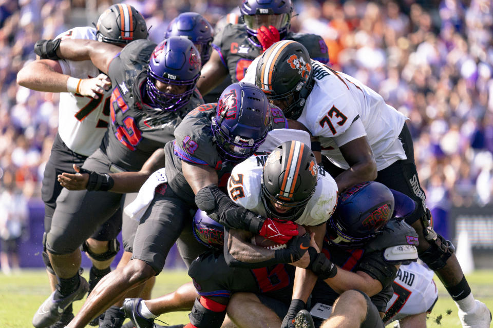 Oklahoma State running back Dominic Richardson is brought down by TCU linebacker Dee Winters (13) during the first half of an NCAA college football game in Fort Worth, Texas, Saturday, Oct. 15, 2022. (AP Photo/Sam Hodde)