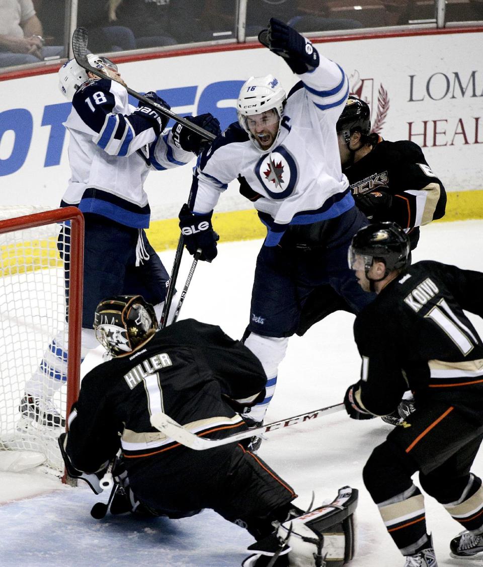 Winnipeg Jets' Andrew Ladd, top right, celebrates a goal by teammate Bryan Little (18) in front of Anaheim Ducks goalie Jonas Hiller, of Switzerland, and Saku Koivu, of Finland, during the first period of an NHL hockey game, Tuesday, Jan. 21, 2014, in Anaheim, Calif. (AP Photo/Jae C. Hong)