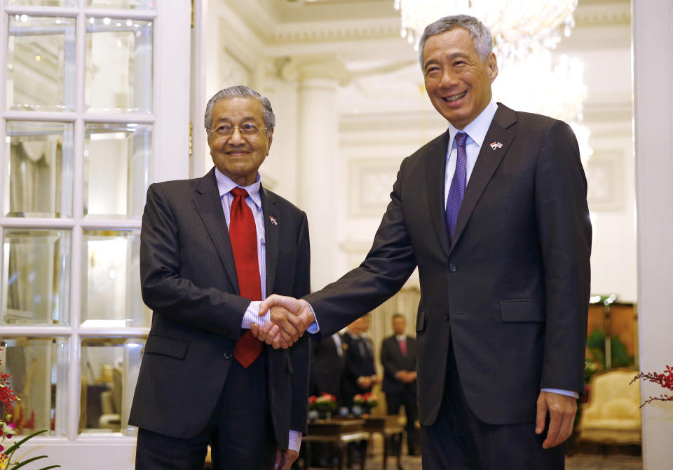 Malaysia's Prime Minister Mahathir Mohamad, left, shakes hands with Singapore's Prime Minister Lee Hsien Loong at the Istana in Singapore, Monday, Nov. 12, 2018. (Feline Lim/Pool Photo via AP)