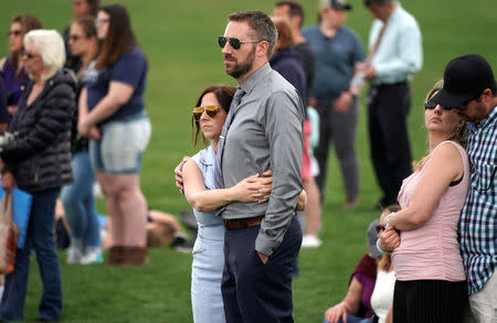 Couples listen during a ceremony to commemorate the 20th anniversary of the Columbine high school attack in Littleton, Colorado, U.S., April 20, 2019. REUTERS/Rick Wilking