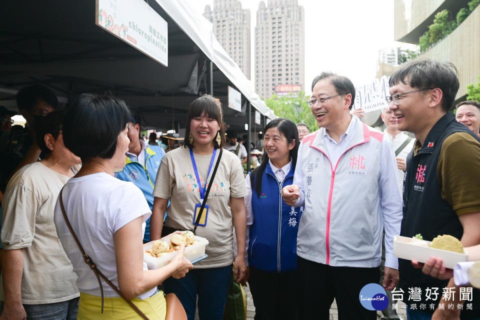 桃園市長張善政出席「植感桃園－植人聚美食祭蔬食市集」與業者們互動。