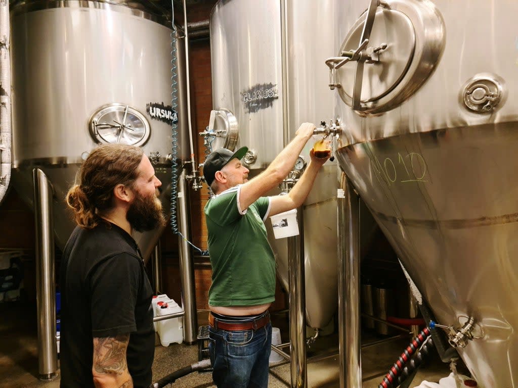 Young Henrys brewery co-founders Oscar McMahon (L) and Richard Adamson pour beer from their fermentation tanks at the brewery in Sydney, Australia (REUTERS)