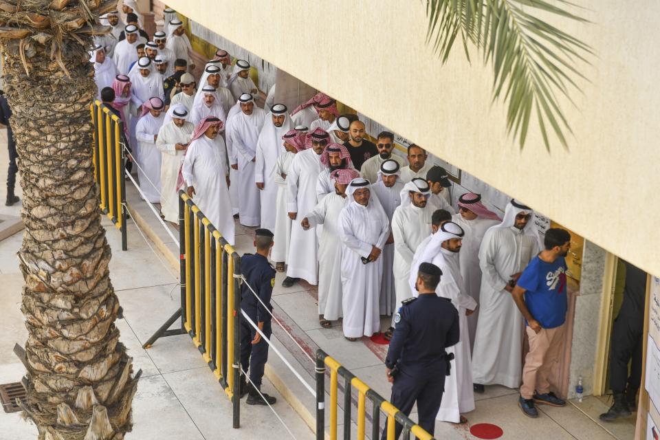 People stand in line to cast their votes for National Assembly elections in Salwa district, Kuwait, Thursday, Sept. 29, 2022. (AP Photo/Jaber Abdulkhaleg)