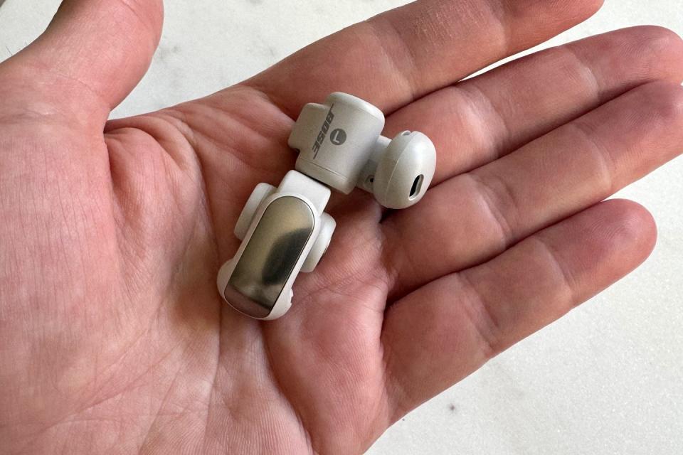 hand holding bose ultra open earbuds