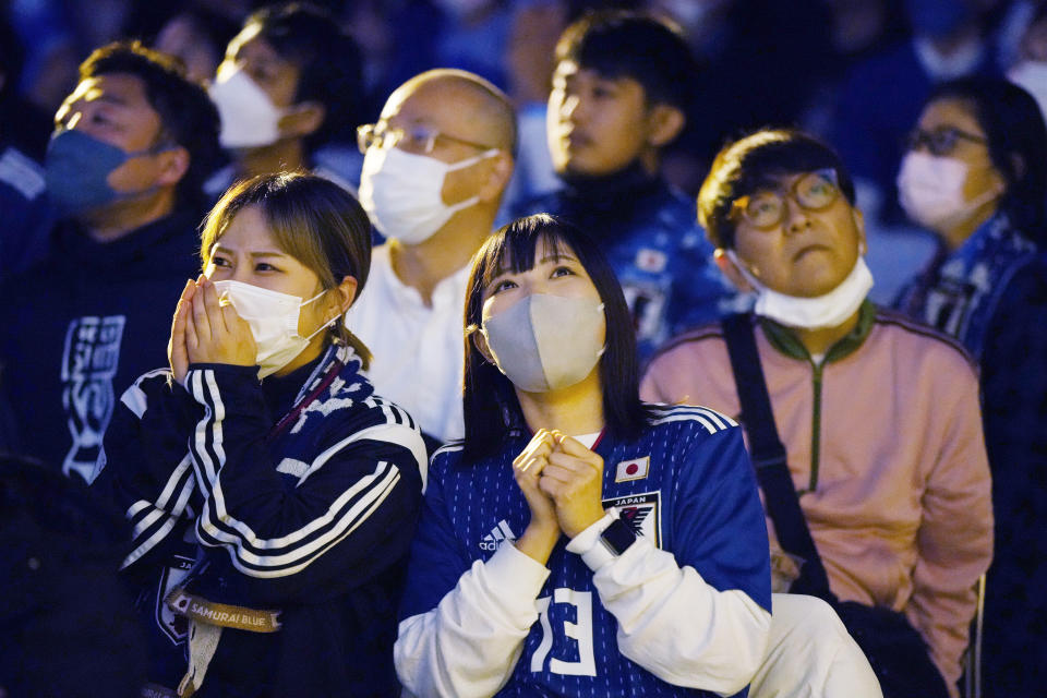 Women pray as they watch on a live stream of the World Cup round of 16 soccer match between Croatia and Japan being played in Doha, Qatar, during a public viewing event in Tokyo, Tuesday, Dec. 6, 2022. (AP Photo/Hiro Komae)