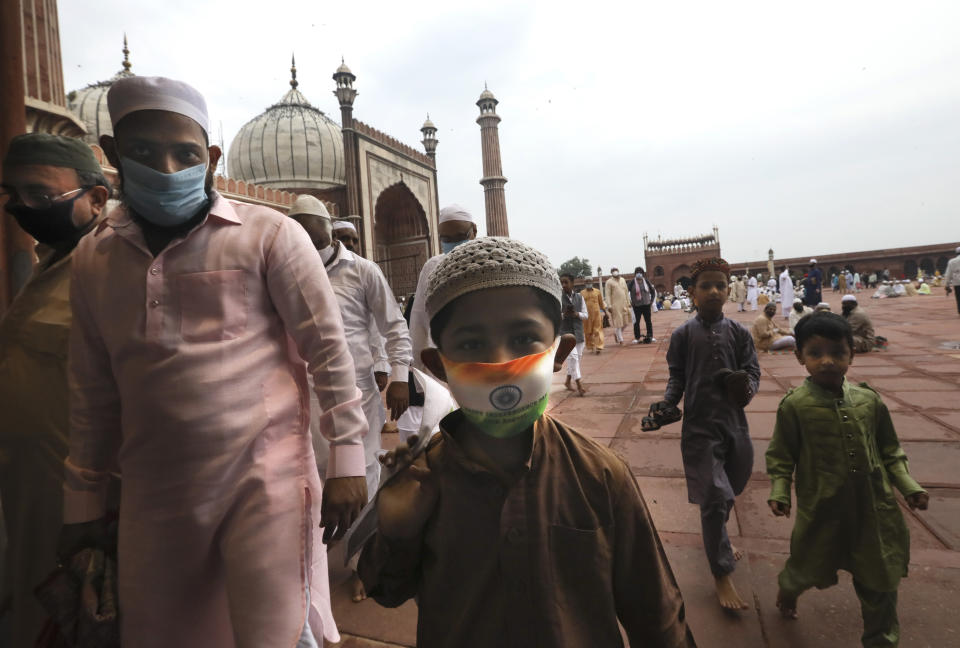 An Indian Muslim boy wears a protective mask in the colors of the Indian national flag, leaves after offering Eid al-Adha prayer at the Jama Masjid in New Delhi, India, Saturday, Aug.1, 2020. Eid al-Adha, or the Feast of the Sacrifice, by sacrificing animals to commemorate the prophet Ibrahim's faith in being willing to sacrifice his son. (AP Photo/Manish Swarup)