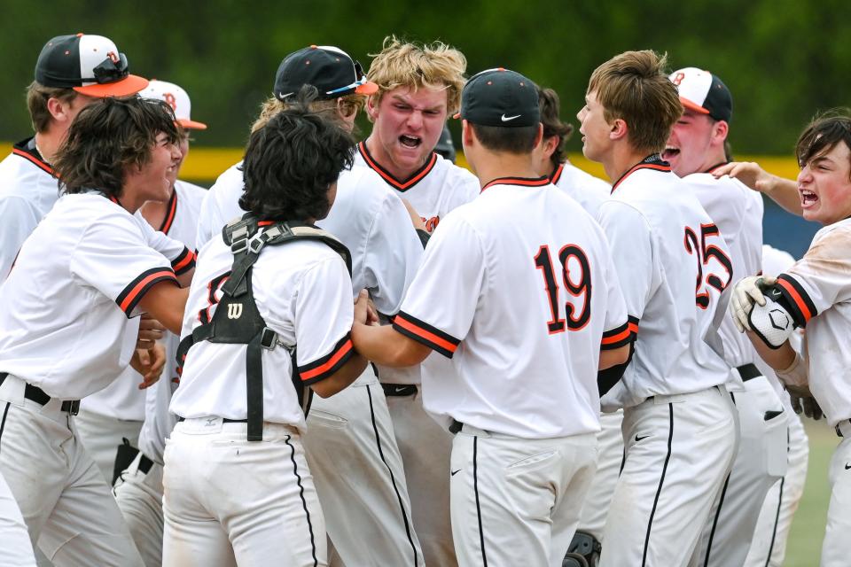 Brighton's Jack Storey, center, celebrates with teammates after beating Howell to win the Division 1 baseball district title on Saturday, June 4, 2022, at East Lansing High School.