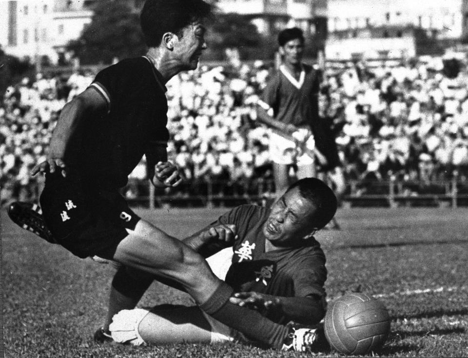 Tung Wah's goalkeeper Kwok Chow-ming, with eyes closed, dived in time to block a shot from Rangers centre-forward Mok King-keung, during the league match at Boundary Street. 23SEP66 (Photo by Chan Kiu/South China Morning Post via Getty Images)