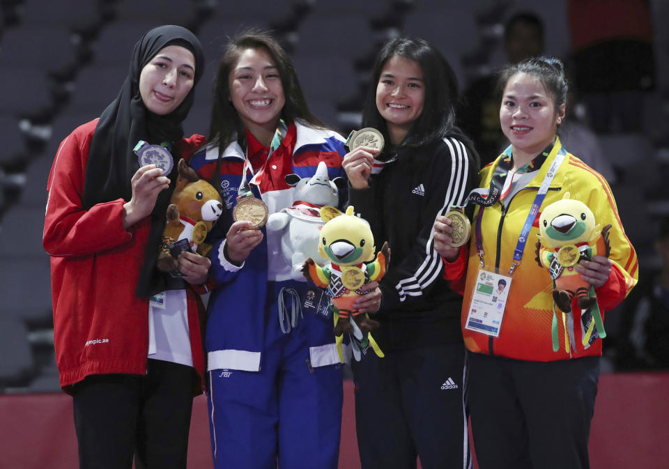 Medalists from left to right, Mahra Alhinaai of United Arab Emirates, with silver, Jessa Khan of Cambodia, with gold, Margarita Ochoa of Philippines and Thi Thanh Duong of Vietnam, with bronze, pose for photograph during the victory ceremony in the newaza women's - 49 kilogram jujitsu at the 18th Asian Games in Jakarta, Indonesia, Friday, Aug. 24, 2018. (AP Photo/Firdia Lisnawati)