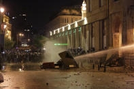 Anti-government protesters are sprayed by a water canon, during ongoing protests against the political elites who have ruled the country for decades, in Beirut, Lebanon, Sunday, Jan. 19, 2020. Lebanese security forces used tear gas, water cannons and rubber bullets in clashes with hundreds of anti-government protesters outside the country's Parliament on Sunday, as violence continued to escalate in a week of rioting in the capital. (AP Photo/Hassan Ammar)