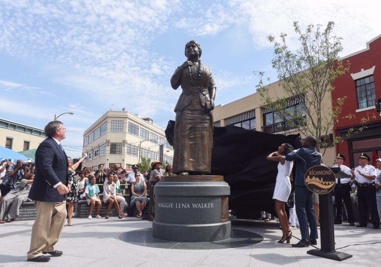 Sculptor Toby Mendez, left, watches Liza Mickens, the great-great-granddaughter of Maggie Walker, and Mayor Levar Stoney unveil a new statue to Walker in Richmond, Va., on July 15, 2017. (Photo: Scott Elmquist/Style Weekly)