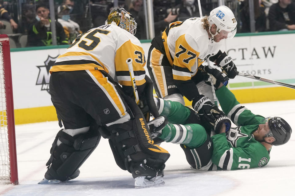 Dallas Stars center Joe Pavelski (16) falls to the ice against Pittsburgh Penguins defender Jeff Carter (77) and goaltender Tristan Jarry (35) during the first period of an NHL hockey game in Dallas, Saturday, Jan. 8, 2022. (AP Photo/LM Otero)