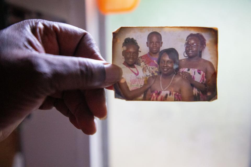 Ed Sutton holds a photograph of his fiancee, Carolyn Benton, with her three kids that was displayed by the bathroom mirror in their home on Aenon Lane. Benton was killed during the severe storm and tornadoes that tore through Tallahassee on Friday.