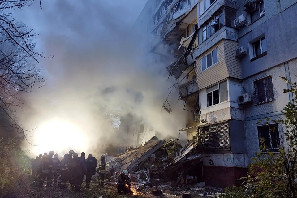 TOPSHOT - Rescuers gather past a residential building damaged after a strike in Zaporizhzhia, amid the Russian invasion of Ukraine on October 9, 2022. (Photo by Maryna Moiseyenko / AFP) (Photo by MARYNA MOISEYENKO/AFP via Getty Images)