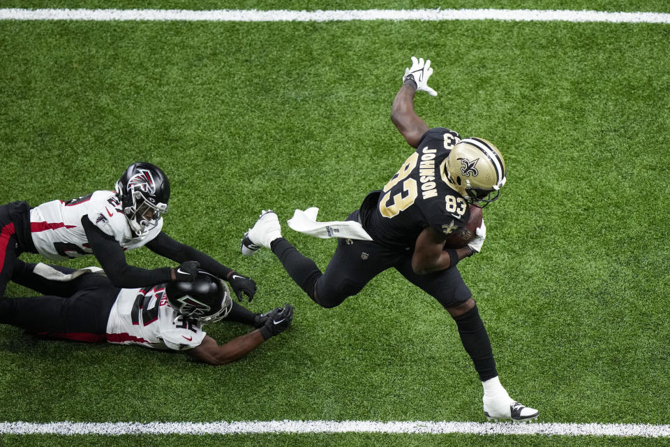 New Orleans Saints tight end Juwan Johnson (83) runs in for a touchdown in front of Atlanta Falcons' Jaylinn Hawkins (32) and Richie Grant (27) in the second half of an NFL football game in New Orleans, Sunday, Dec. 18, 2022. (AP Photo/Gerald Herbert)