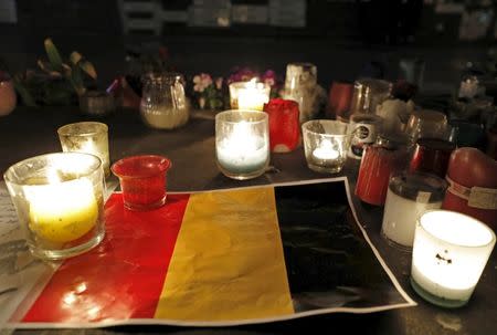 Candles are pictured around a Belgian flag on the Place de la Republique in Paris, France following bomb attacks in Brussels, Belgium, March 22, 2016. REUTERS/Philippe Wojazer