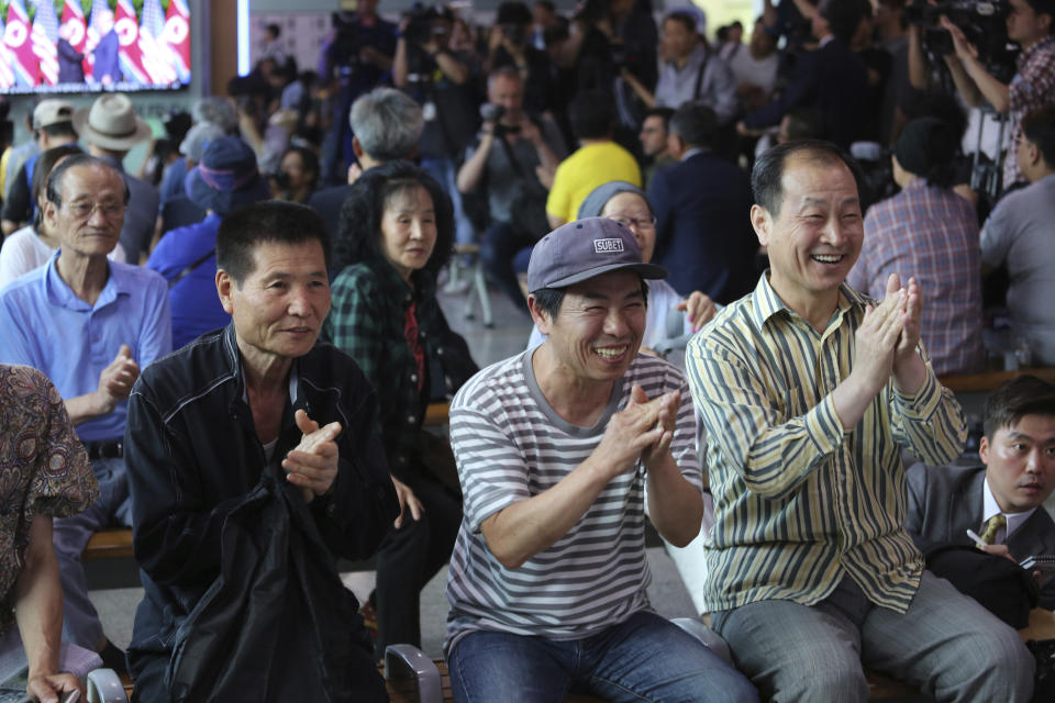 FILE - In this June 12, 2018, file photo, people celebrate as they watch a TV showing U.S. President Donald Trump meeting with North Korean leader Kim Jong Un during a news program at the Seoul Railway Station in Seoul, South Korea. Trump and Kim are planning a second summit in the Vietnam capital of Hanoi, Feb. 27-28. (AP Photo/Ahn Young-joon, File)