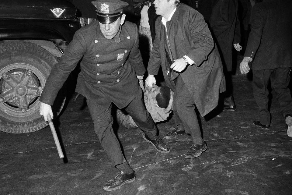 Police drag away one person from a store after he smashed a window in New York's Times Square on April 5, 1968, as disturbances spread over many sections of New York City in the wake of the assassination of Dr. Martin Luther King. King was shot in Memphis, Tenn., on April 4. (AP Photo)