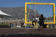 Visitors to Cape Town's popular V&A Waterfront are photographed against a backdrop of the city's Table Mountain, Friday, July 31, 2020. For growing numbers of businesses and individuals who depend on the global tourism industry, the question is not so much when the coronavirus pandemic will end but how and if they'll survive until business picks up. (Photo/Nardus Engelbrecht)