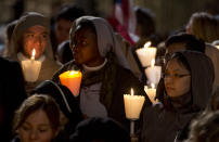 Faithful attend the Via Crucis (Way of the Cross) torchlight procession celebrated by Pope Francis in front of the Colosseum on Good Friday in Rome, Friday, April 18, 2014. (AP Photo/Gregorio Borgia)