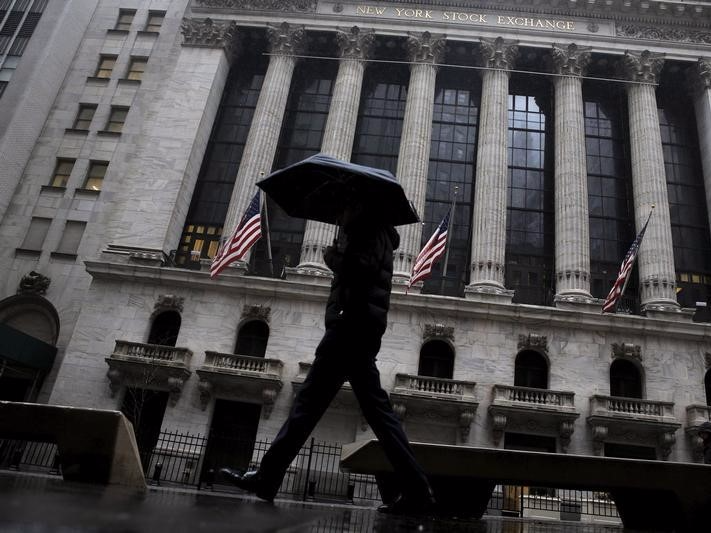 A man passes by the New York Stock Exchange during a rain storm in New York February 24, 2016.  REUTERS/Brendan McDermid   