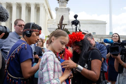 Swedish environment activist Greta Thunberg (C) speaks with Militza Flaco (R) from the Global Alliance of Territorial Communities Guardians of the Forest after a gathering outside the US Supreme Court