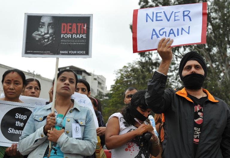 Protesters wear black ribbons and hold placards during a demonstration in Bangalore, on December 29, 2012, after the death of a gang rape victim from the Indian capital New Delhi