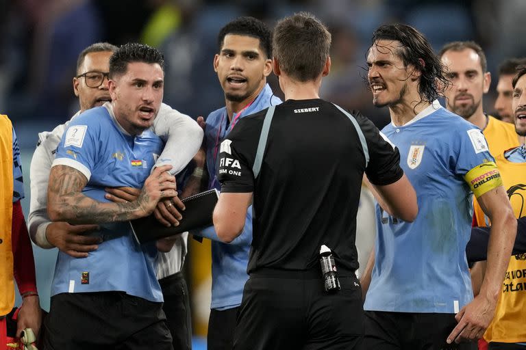 Edinson Cavani le reclama al árbitro Daniel Siebert los dos penales no cobrados, en un partido que terminó con polémica (AP Photo/Darko Vojinovic)