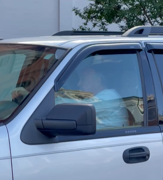 A still, taken from footage shot May 7 outside the Market House, shows a man sitting behind the wheel of an SUV with a N.C. Appeals Court license plate that protestors allege tried hitting demonstrators.