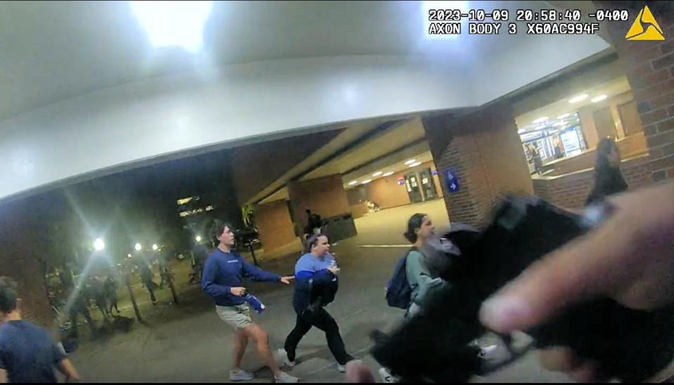 University of Florida police Lt. Scott J. Silver advances with his service pistol toward the start of a panicked stampede during a nighttime vigil on campus Oct. 9, 2023, for Israelis killed in Hamas attacks, as seen in newly released video from his police body camera. Police later concluded the students panicked because a woman in the crowd had fainted and her boyfriend shouted for others to call 911
