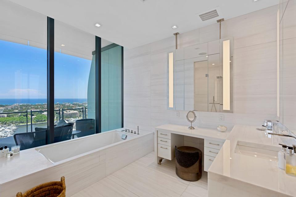 The primary suite’s marble-appointed bathroom offers an ocean view.